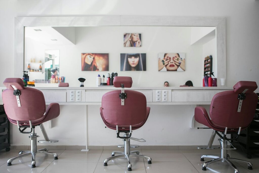 Kapsalon met roze stoelen en spiegels