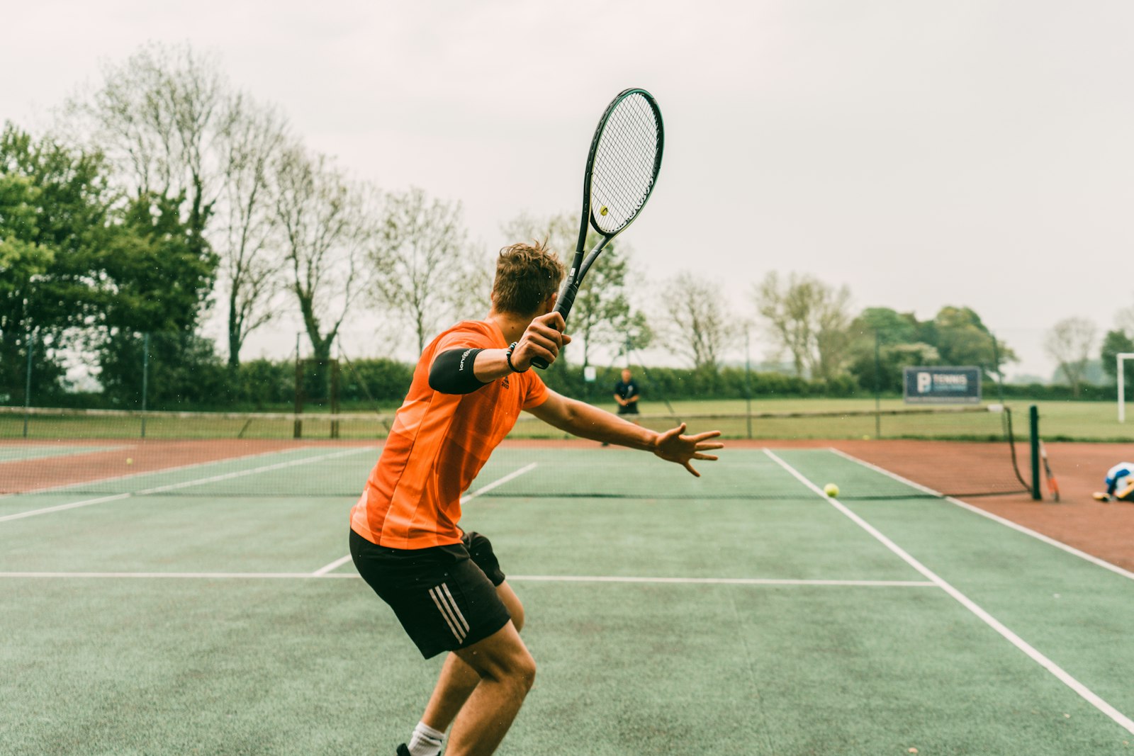 Tennisser slaat een bal op de baan